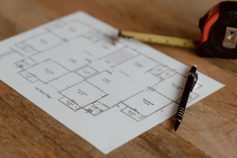 Rzut architektoniczny, długopis i miarka na drewnianym stole