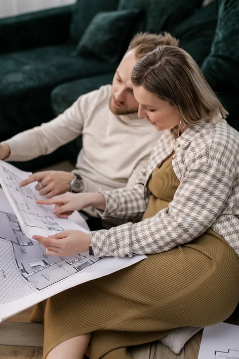 Dwie osoby oglądające rozwinięty projekt budynku
